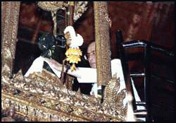 [His Majesty replaces the Emerald Buddha's summer costume with that for the rainy season]